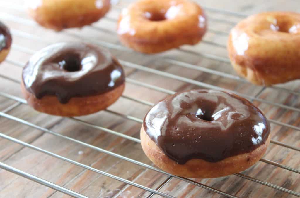 chocolate and yeast donuts on a cooling rack