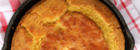 baked cornbread in a cast iron skillet on a red napkin