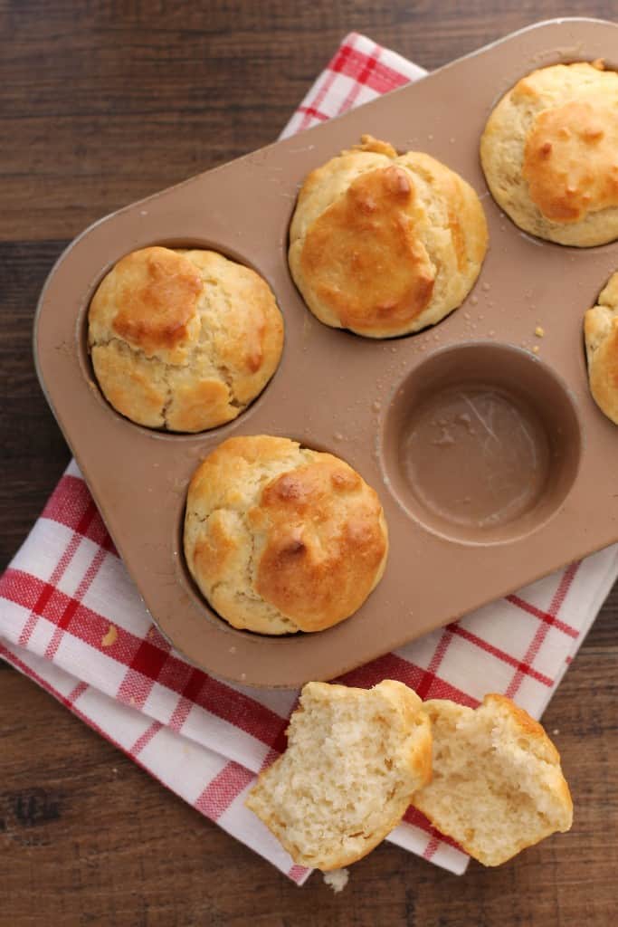 a muffin baking pan with dinner rolls  on a red napkin 