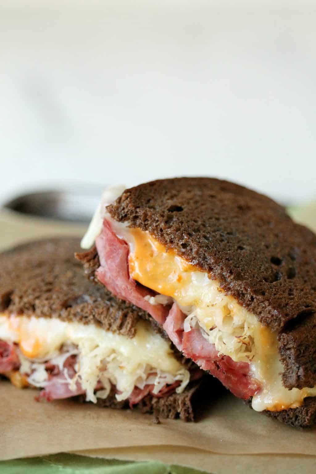 a close up of melted cheese in the cut sides of a reuben sandwich