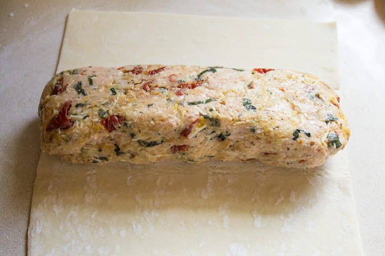formed chicken meatloaf laid on puff pastry to be wrapped 
