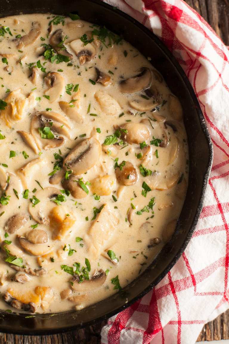 chicken and mushroom cream sauce in a  cast iron skillet on a red and white napkin