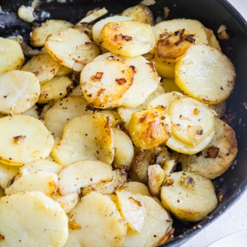 a skillet of southern fried potatoes and onions on a table