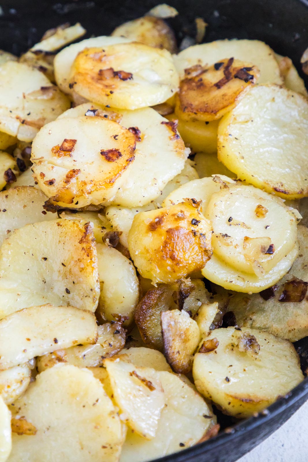 a pan of fried sliced fried potatoes and onions 