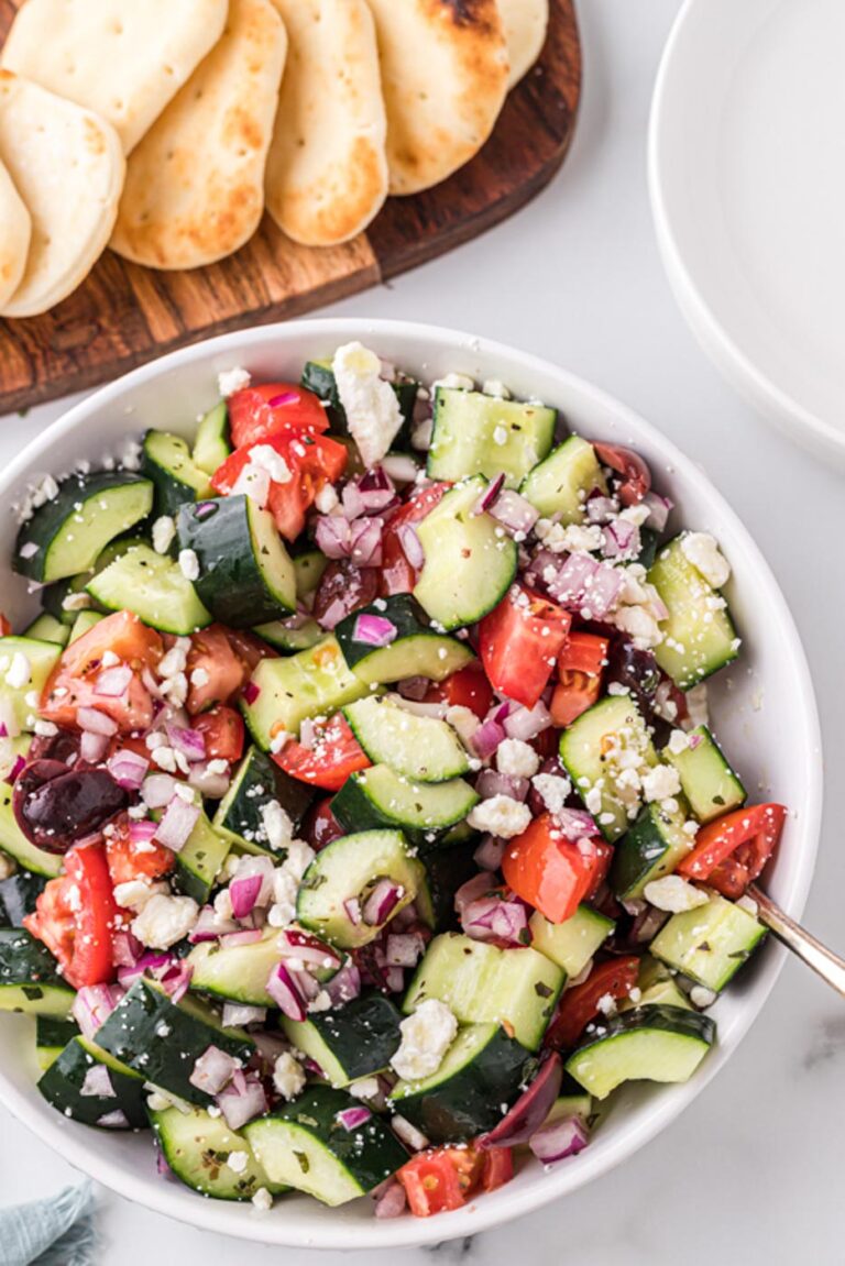 a bowl of greek cucumber salad with pita chips on the side