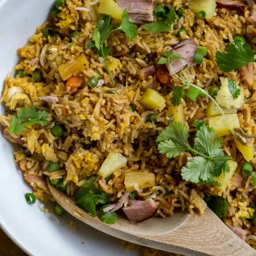 fried rice in a bowl with wooden spoon