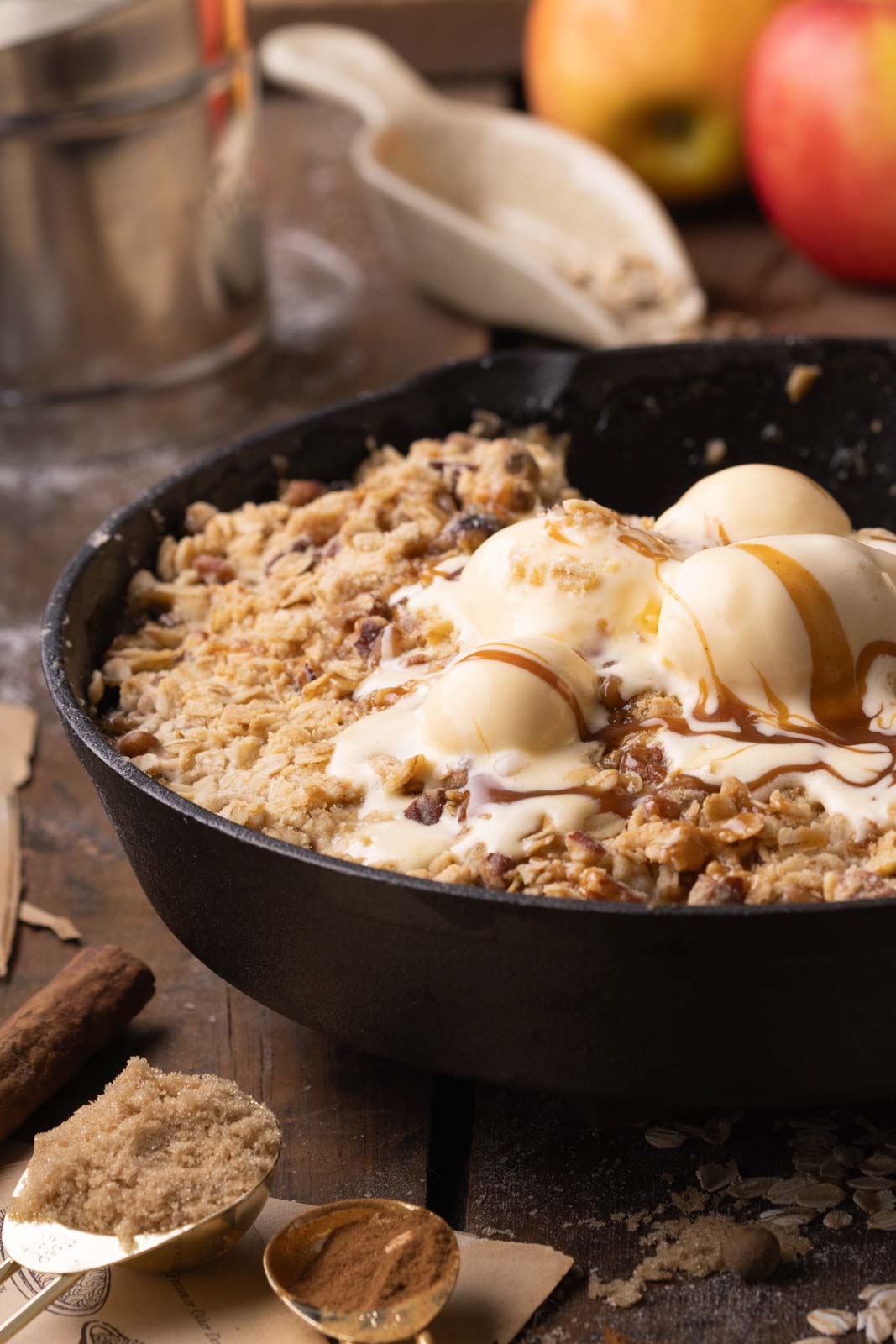 a skillet of apple pear crisp baked with ice cream scoops on top