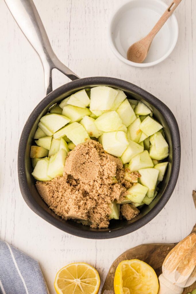 a pot with diced apples and brown sugar on a table