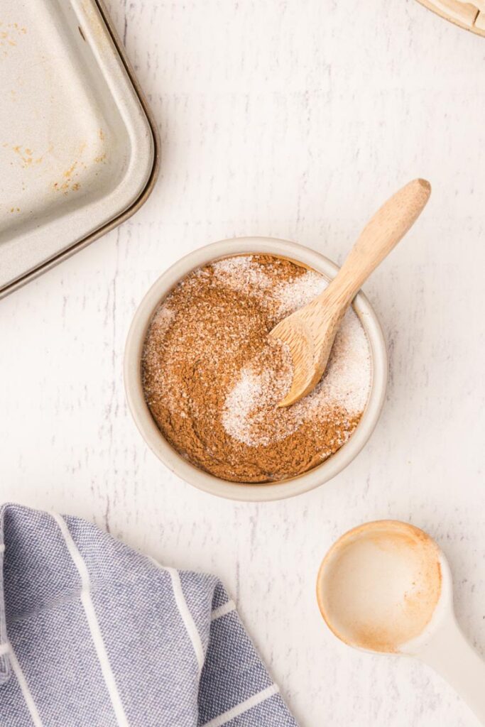 a bowl of cinnamon and sugar with a spoon
