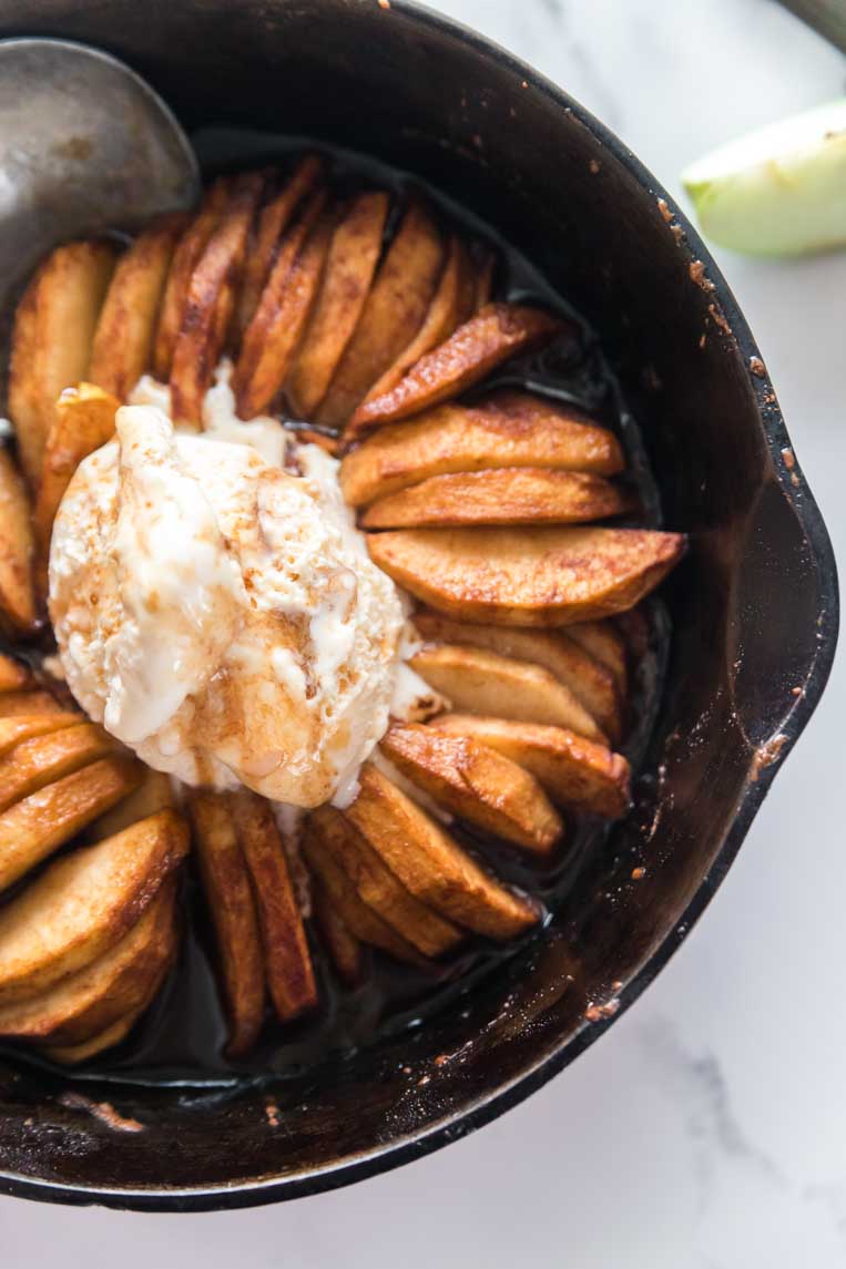 a skillet of baked apple slices in a skillet with ice cream