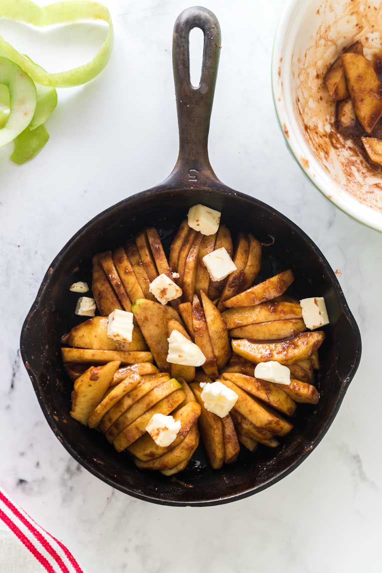 a skillet of apple slices with butter on top