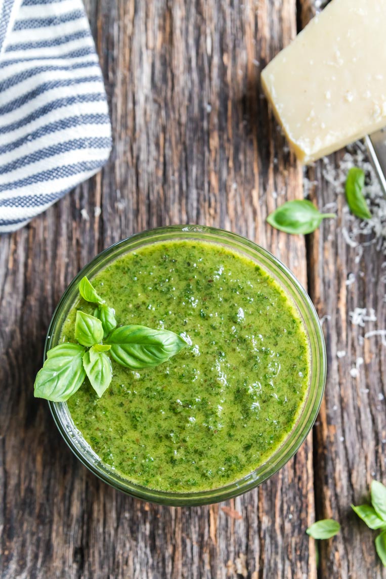 a bowl of basil pesto without pine nuts on a table