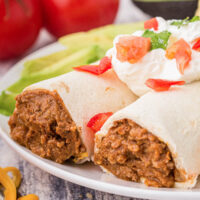 two burritos on a plate with filling exposed