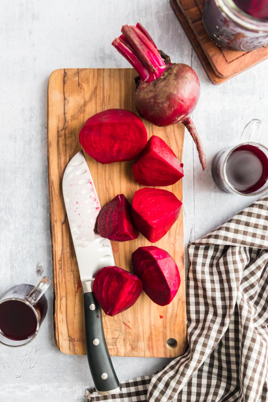 a cutting board with beets and a knife