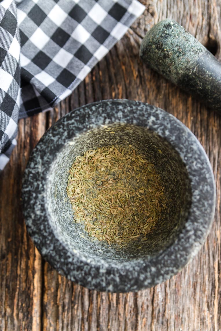 a mortar and pestle with ground fennel inside 