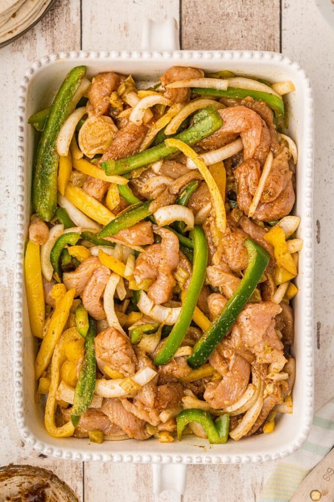  9 by 13 pan of chicken and peppers with the spice mixture stirred in an ready for baking. 