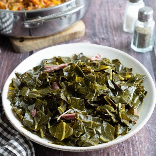 A bowl full of southern collard greens with ham hocks.