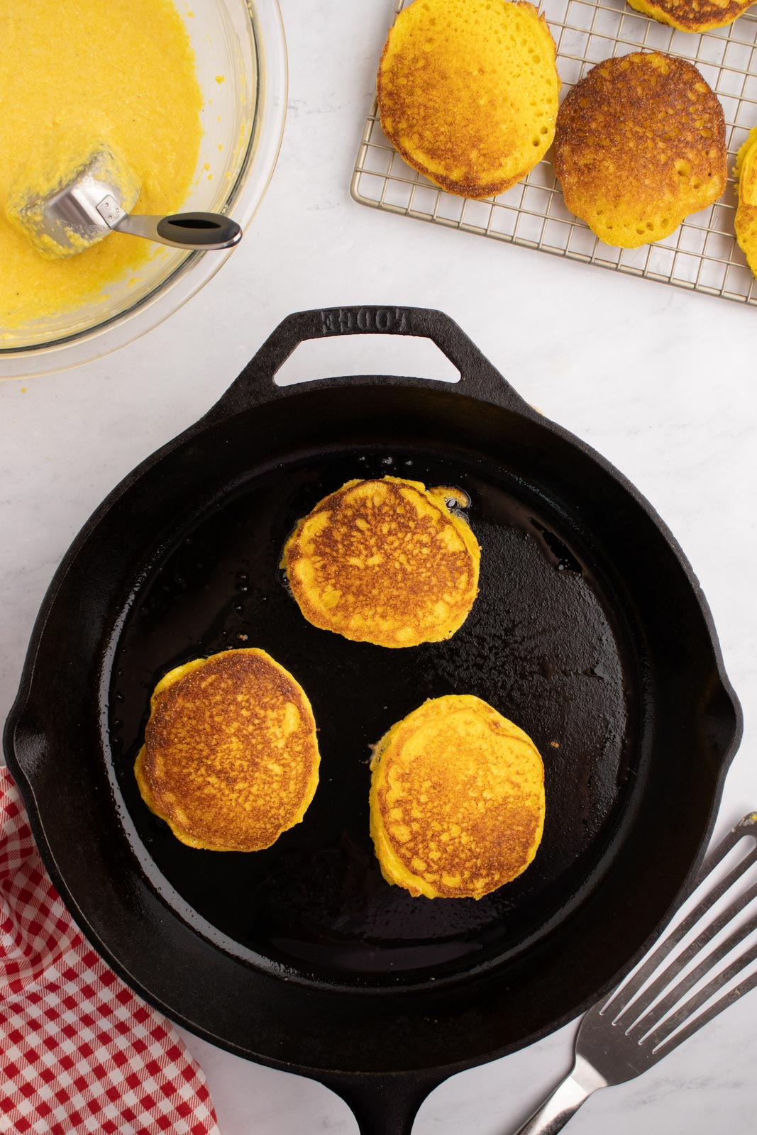 Frying cornbread cakes in a cast iron skillet.