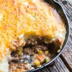 a skillet of cottage pie with a scoop out