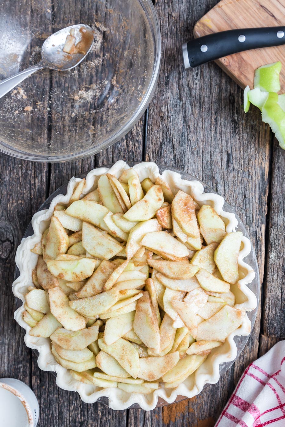 sliced apples piled in a pie crust 