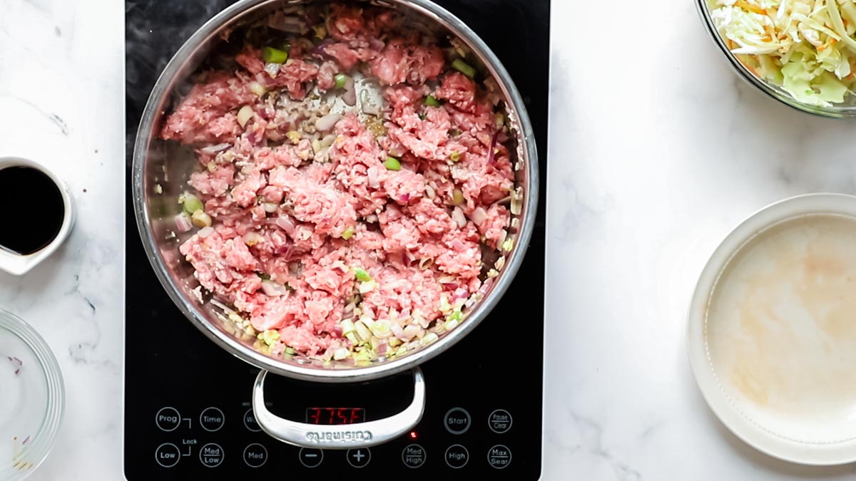 ground pork added to skillet to cook 