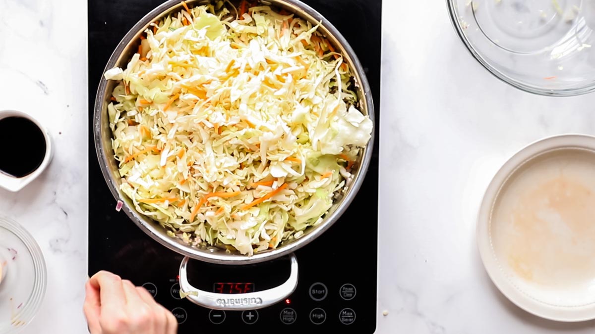 cabbage added to skillet while making egg roll bowls