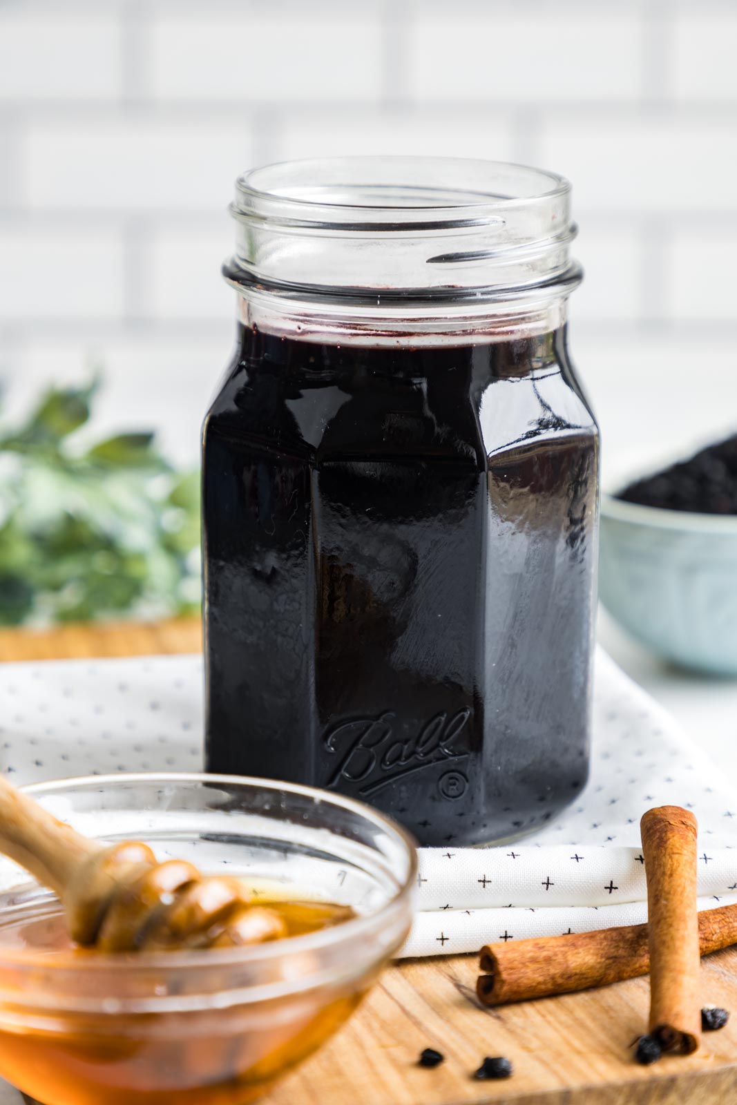 a jar of elderberry syrup on a table 