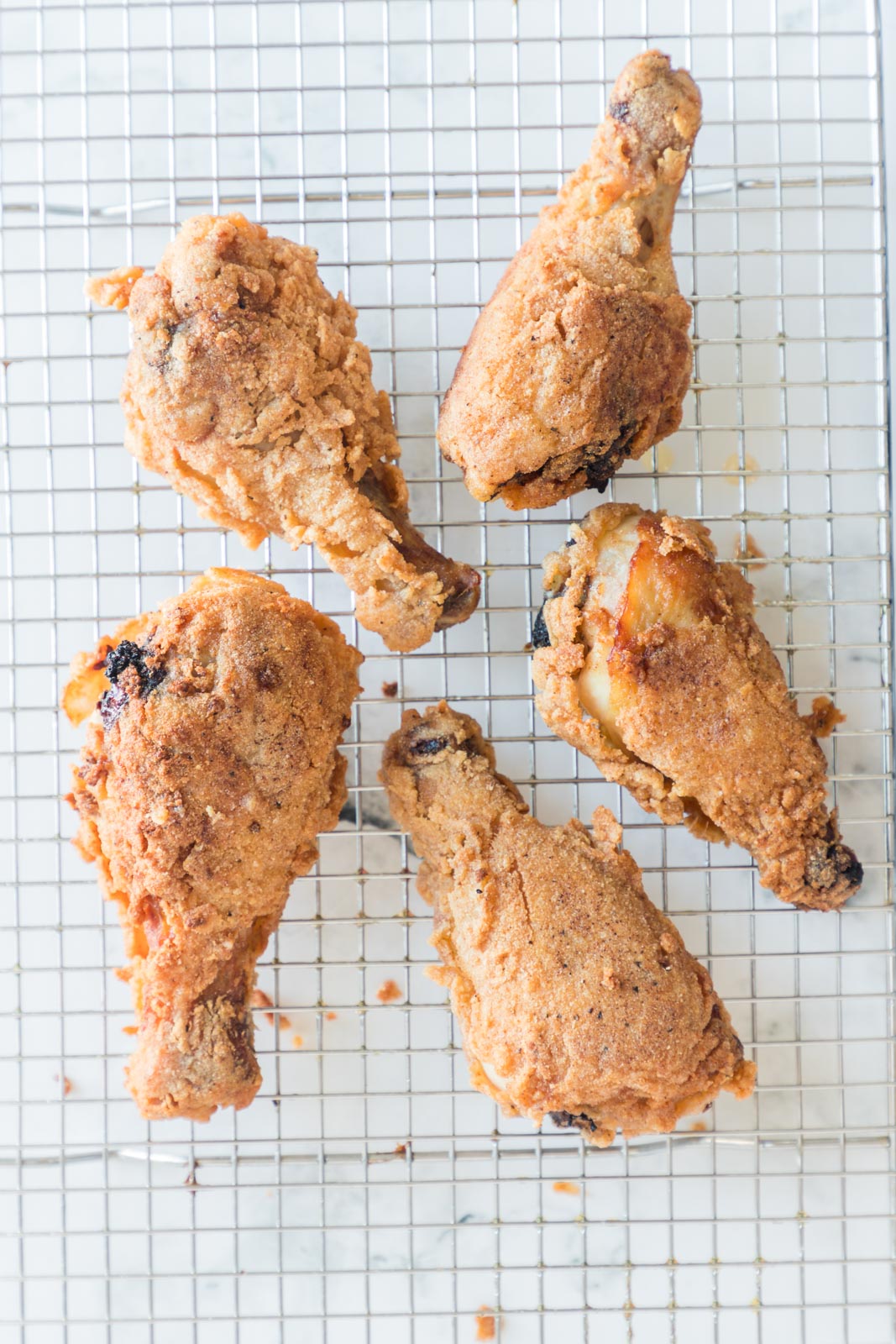 a cooling rack with fried chicken legs cooling