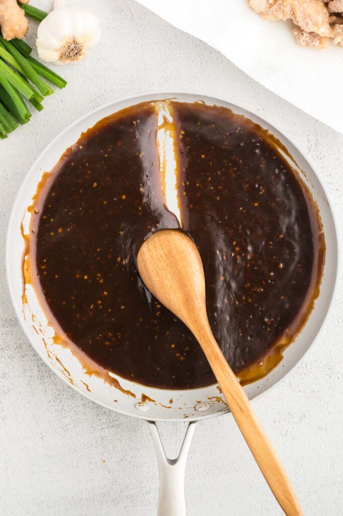 thickened sauce in a skillet with a spoon to show thickness. It should hold a trail. 