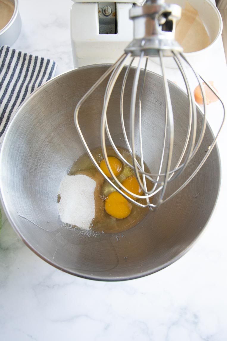 three eggs and sugar in a stand mixer 