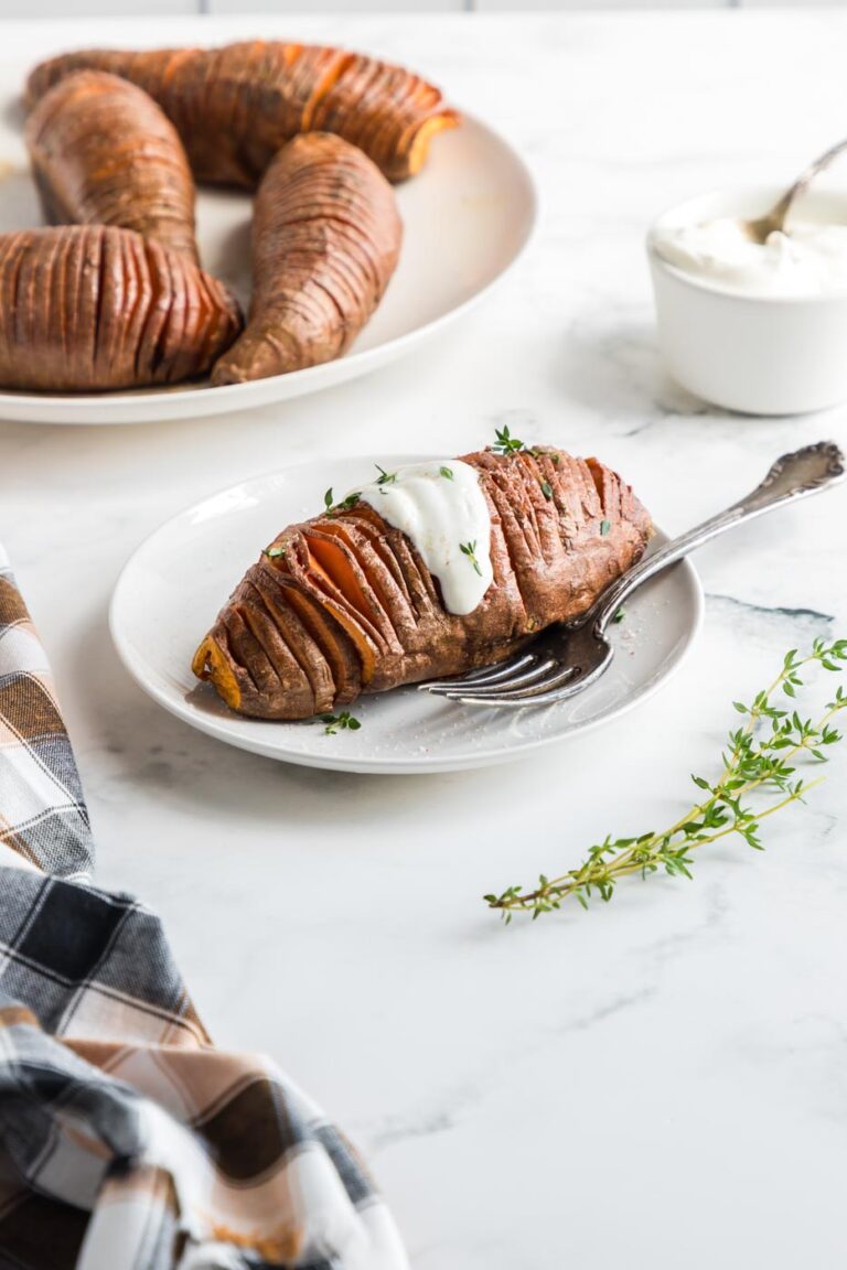 hasselback sliced sweet potato baked and topped with butter and savory herbs