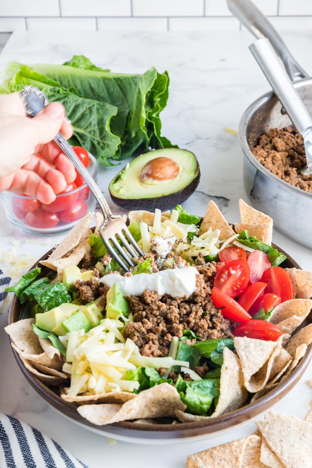 a bowl of loaded healthy taco salad bowls with a fork