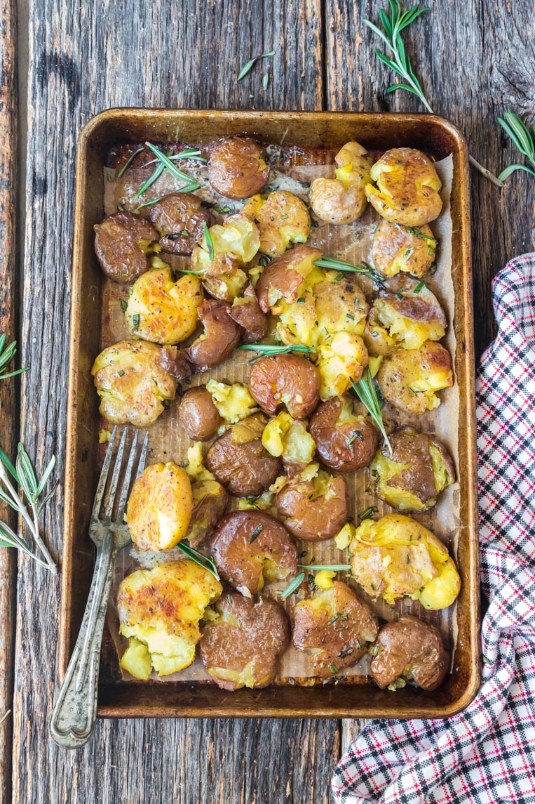 a baking tray with roasted potatoes and a spatula 