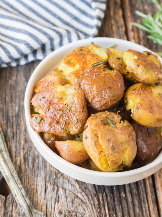a bowl of little potatoes with rosemary and butter