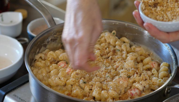bread crumbs being added to the lobster mac and cheese 