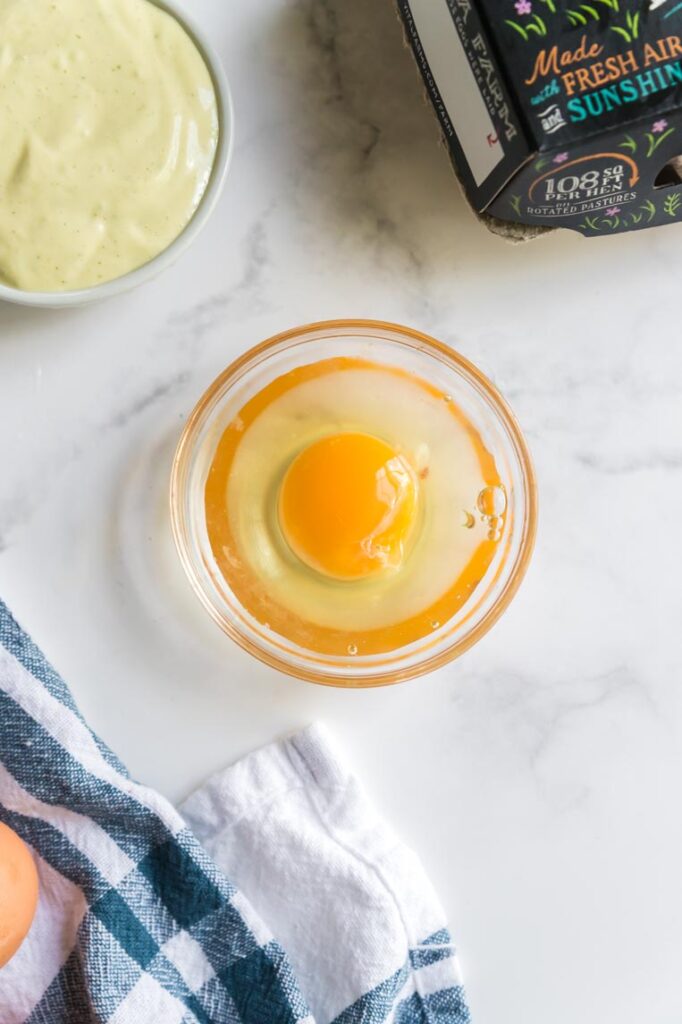 A fresh pastured egg in a clear bowl