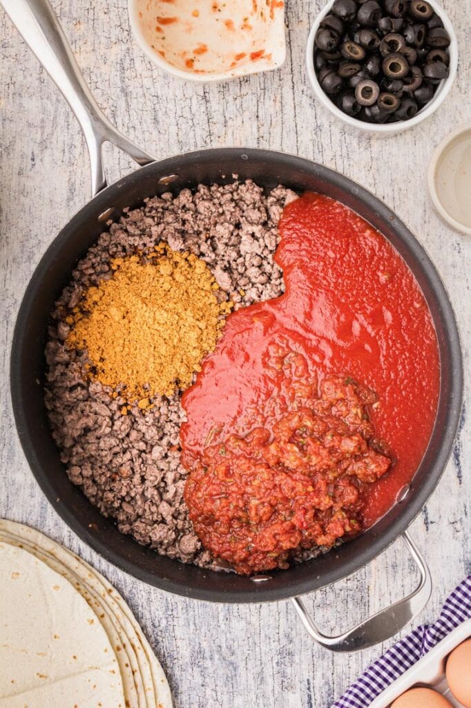 a skillet of ground beef with tomato sauce, and spices 