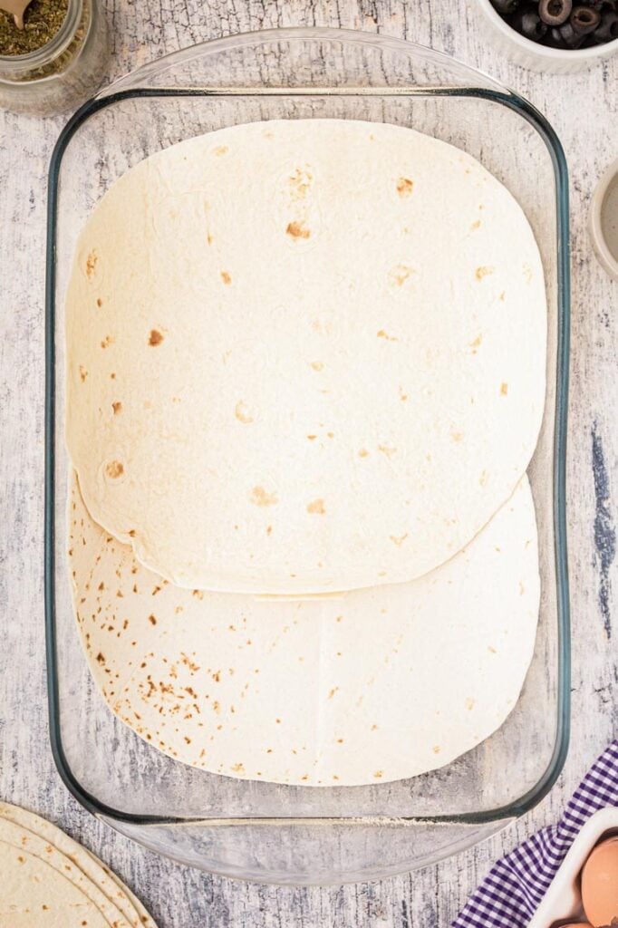 A 9 by 13 pan layered with flour tortillas 