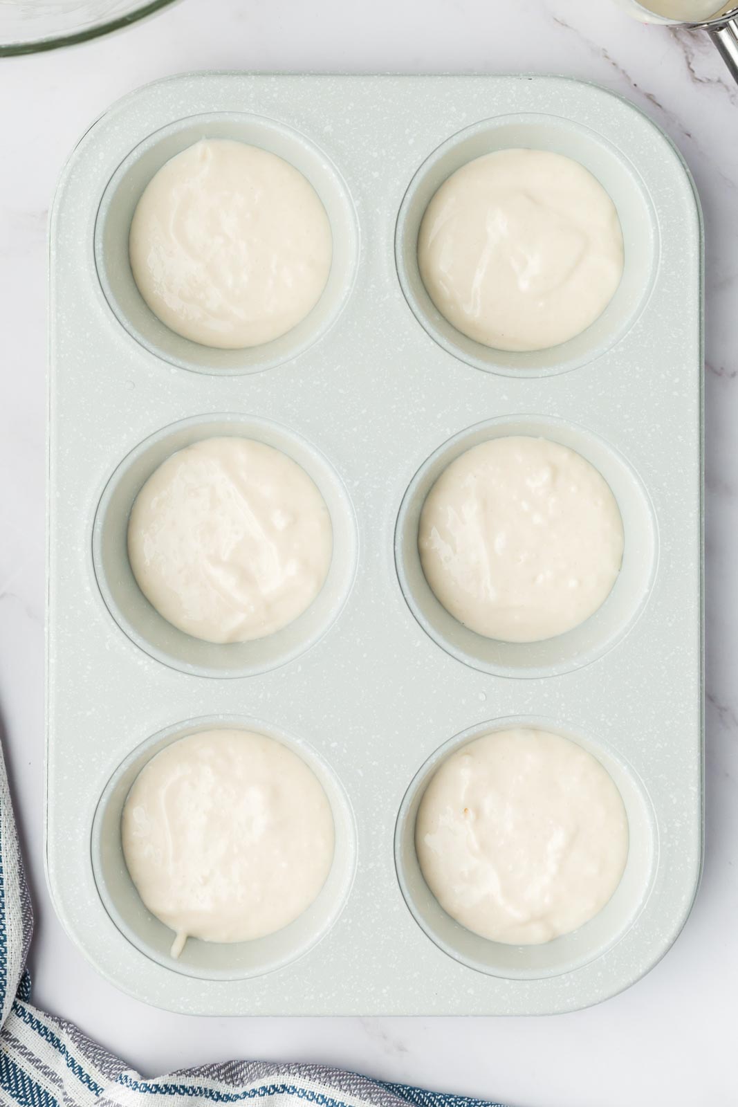 a muffin tin filled with roll batter 