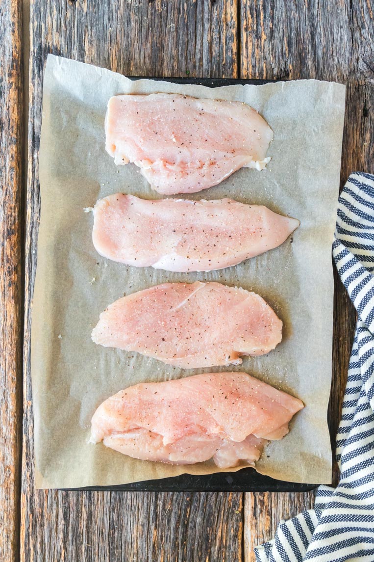 four chicken breasts on a cookie sheet