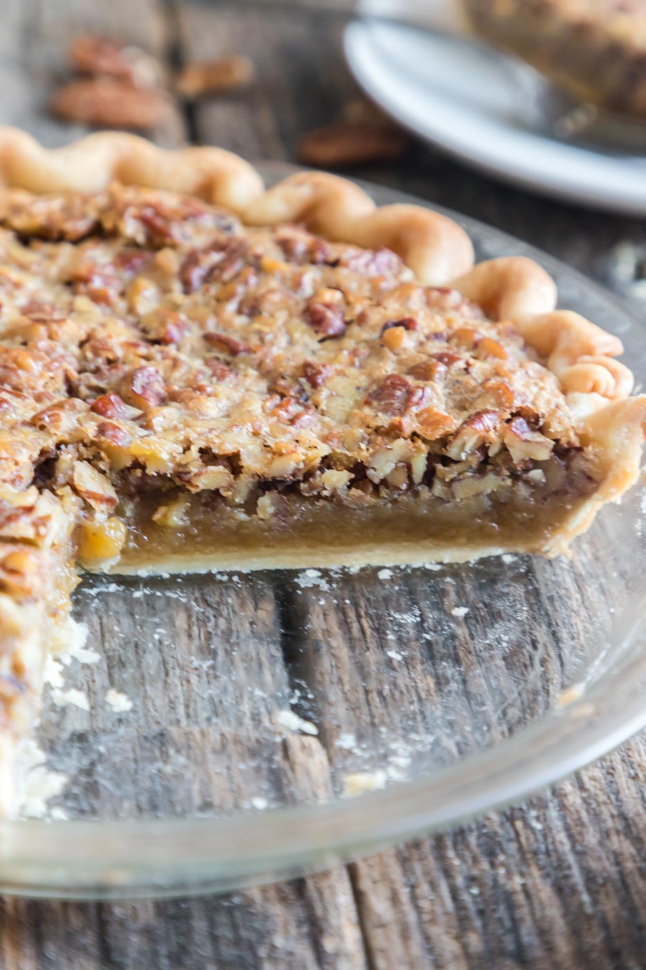 a side view of baked pecan pie with a slice missing 