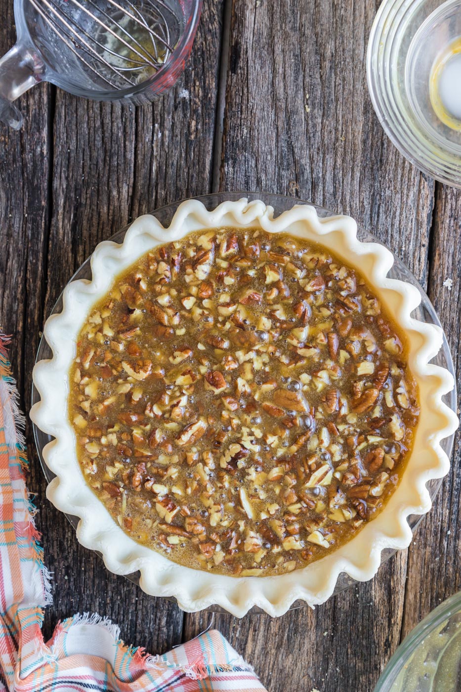 an unbaked pie shell with pecan pie filling inside