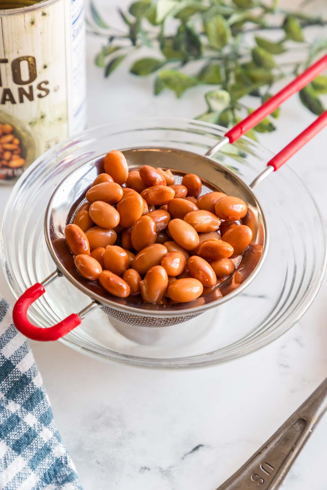 a strainer with rinsed pinto beans over a bowl 