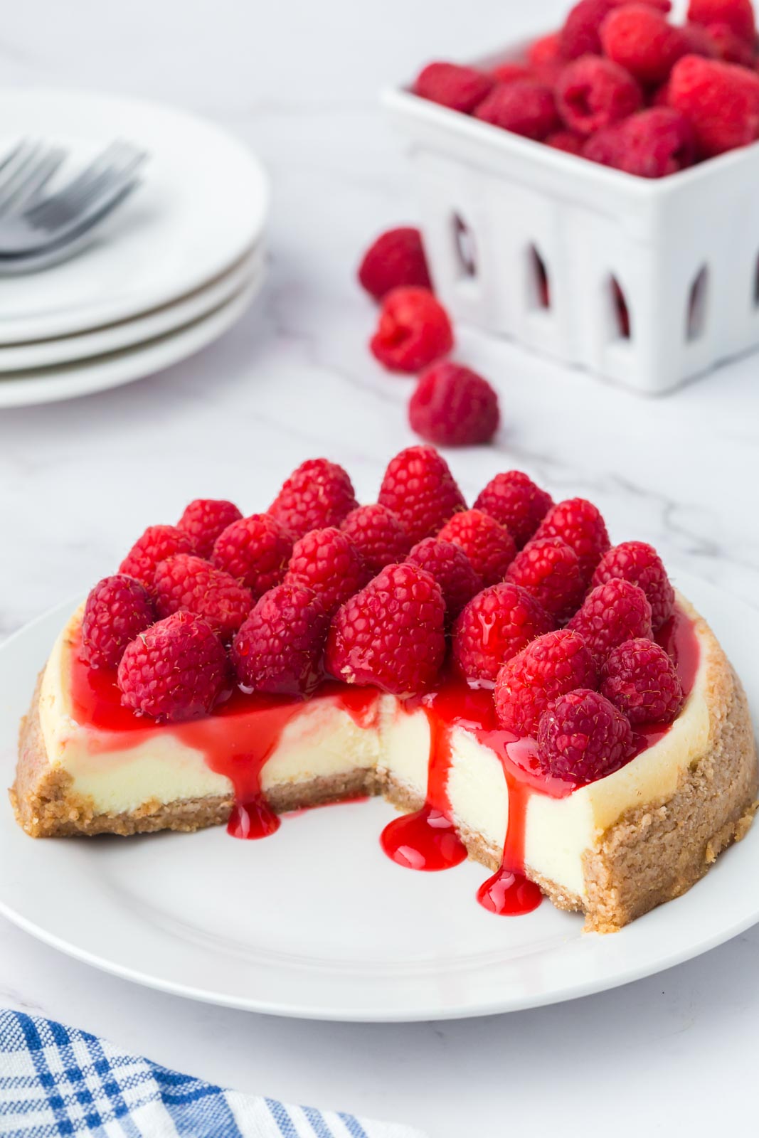Raspberry cheesecake with a couple of slices taken out of it.