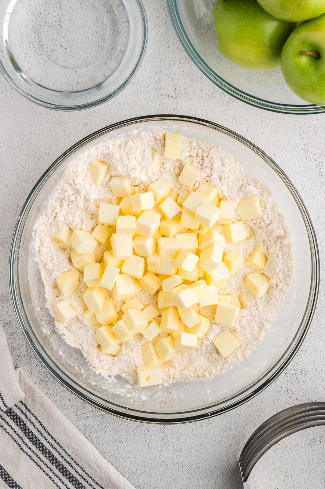 a bowl of dry flour with cold cubed butter in a bowl 