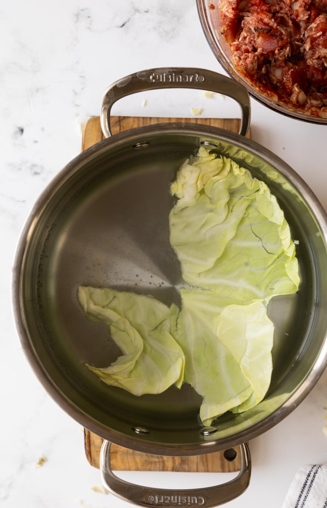 a cabbage leaf in a pot of simmering water