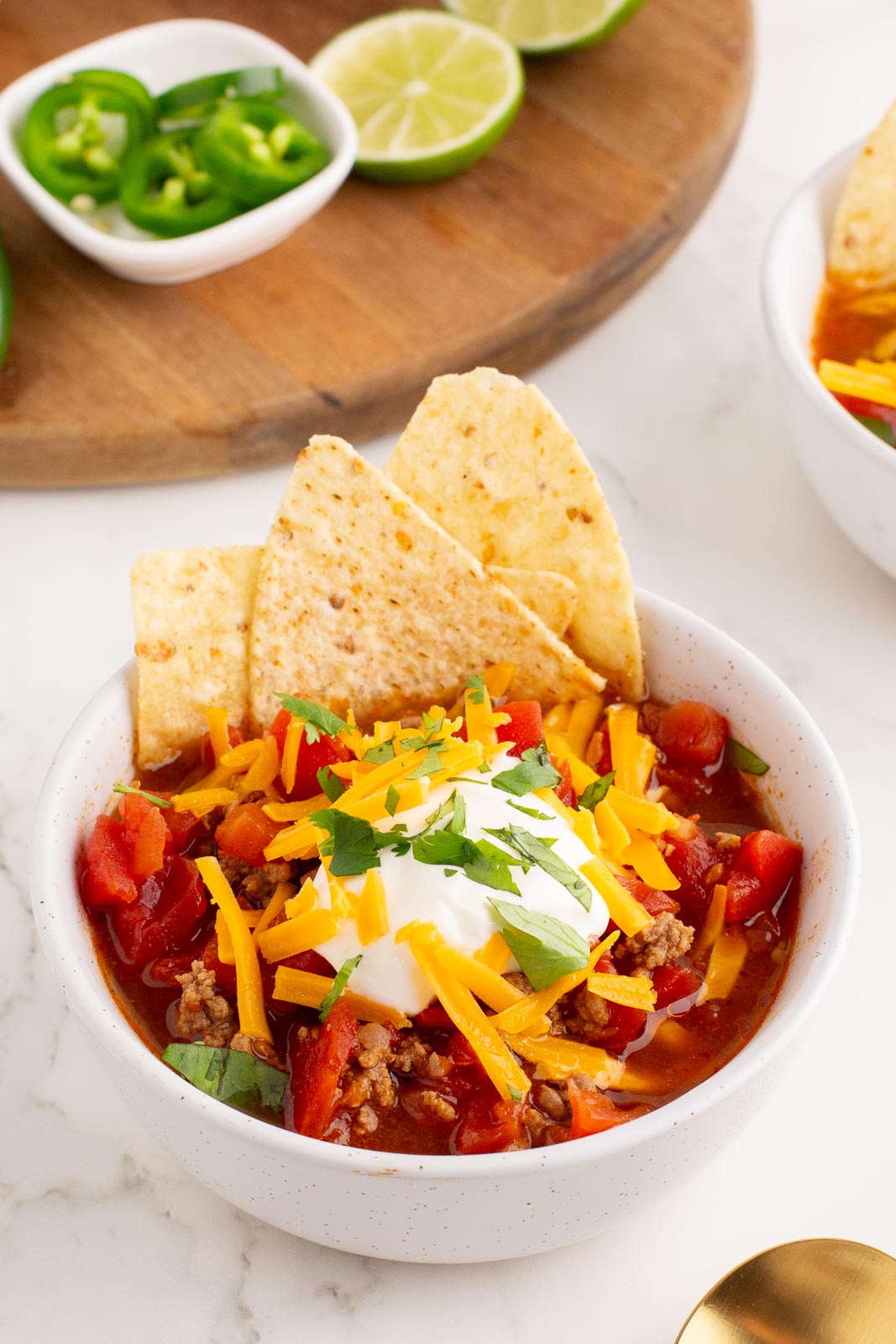 a bowl of 5 ingredient taco soup on a table with toppings 