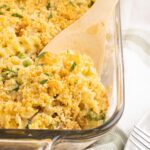 Scooping tuna noodle casserole out of the baking dish.