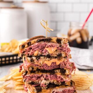 a stack of reuben sandwiches on a cutting board