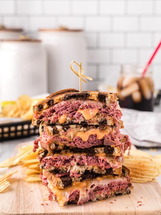 a stack of reuben sandwiches on a cutting board